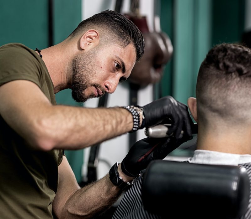 barber-trims-mustache-of-dark-haired-man-at-a-barbershop.jpg